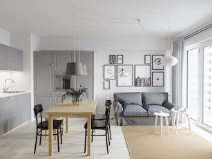 Biało szary pokój dzienny z jadalnią i aneksem kuchenny w stylu skandynawskim