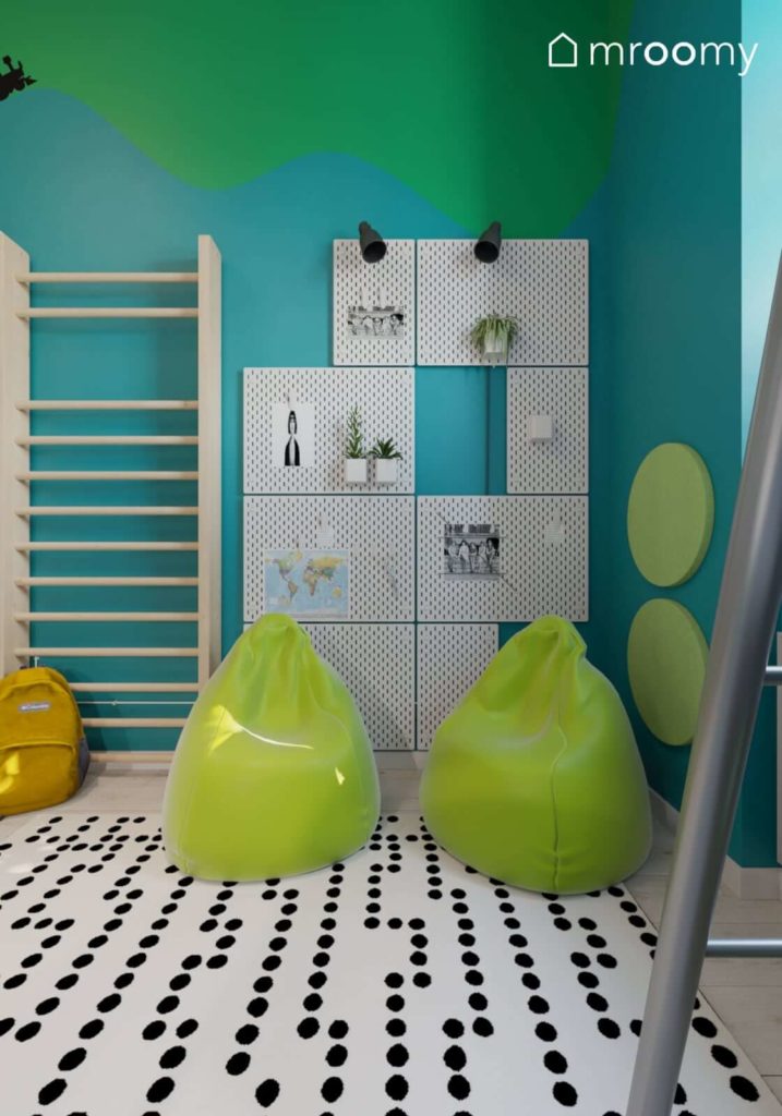 Zielone pufy worki sako obok drabinki gimnastycznej i tablic organizerów na niebieskiej ścianie w pokoju chłopca i dziewczynki