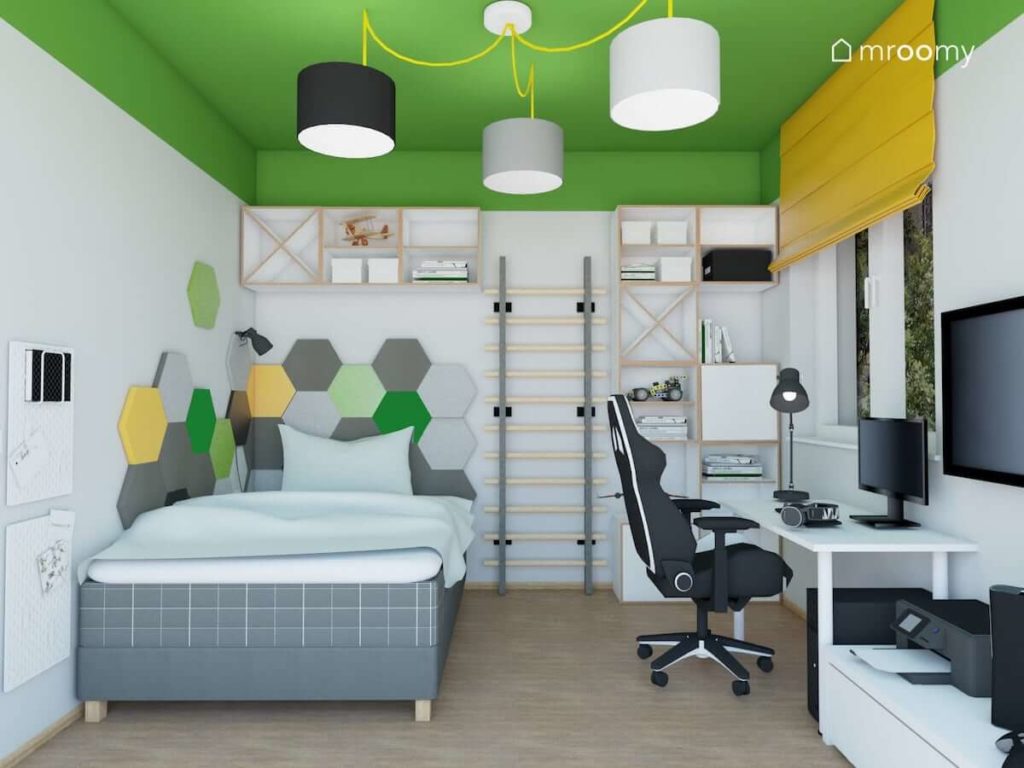 Duże biurko fotel gamingowy i łóżko w biało-zielonym pokoju nastolatka