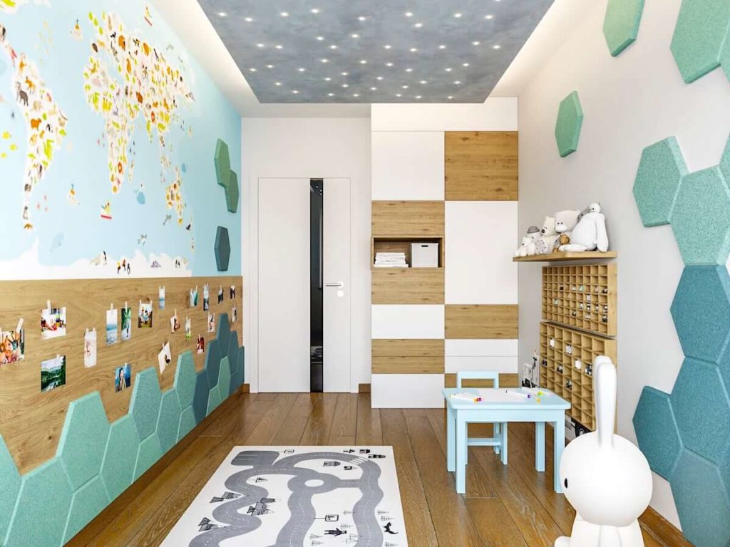 Pokój chłopca w którym jest ściana z mapą świata dywan i stolik w kolorze niebieskim