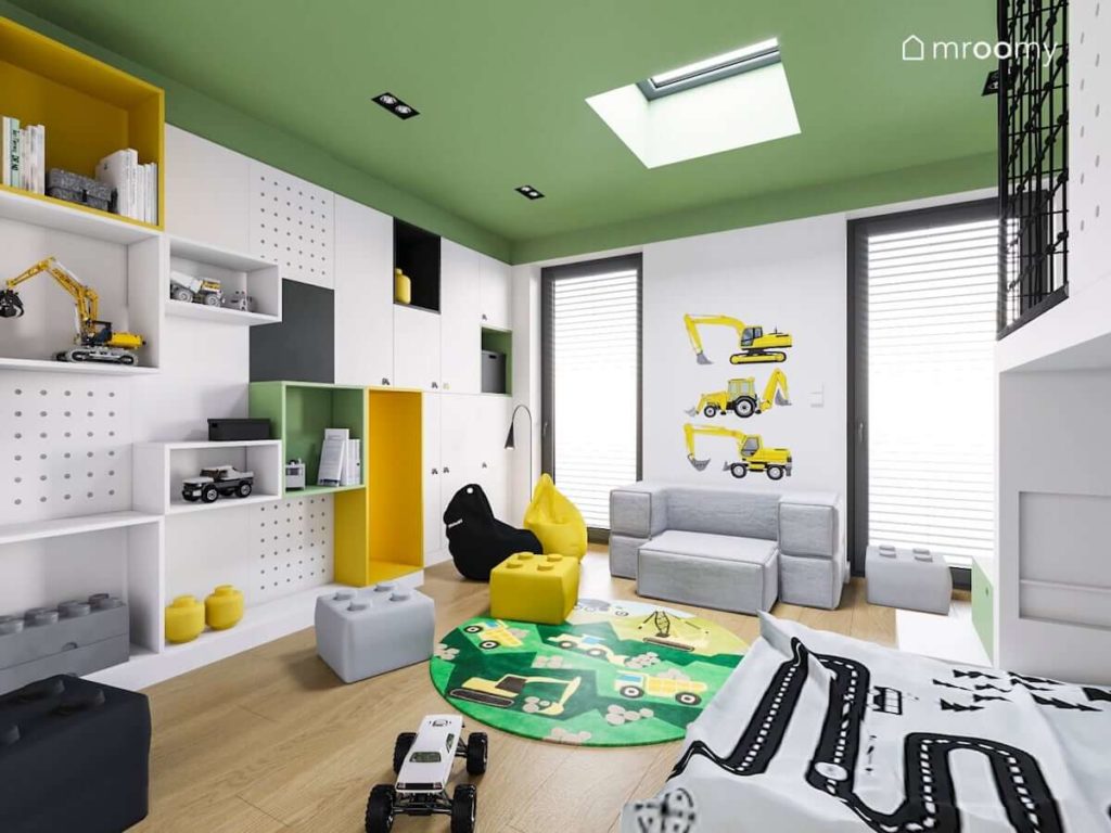 Pokój małego chłopca z zielonym sufitem żółtym i czarnym workiem sako szarą sofą i naklejkami z koparkami