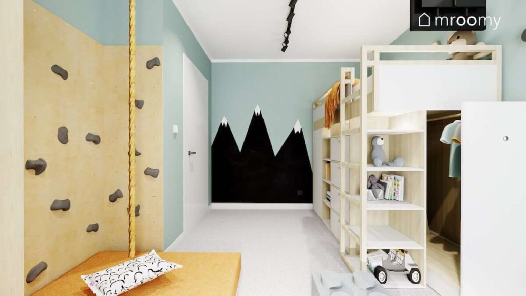 Góry namalowane na miętowej ścianie piętrowe łóżko i ścianka do wspinania w pokoju małego chłopca