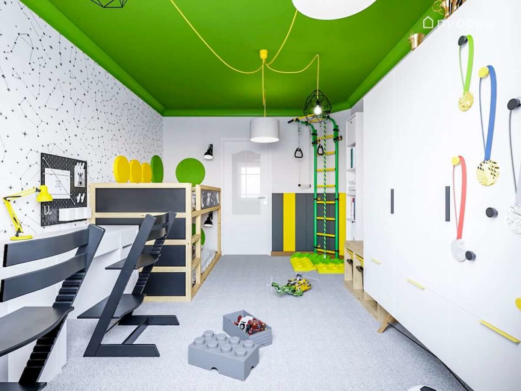 pokój dla dwóch chłopców z zielonym sufitem i czarno białą tapetą w gwiezdne konstelacje  z piętrowym łóżkiem Kura żółto zielona drabinka gimnastyczna miękkie panele ścienne i Szara wykładzina dywanowa