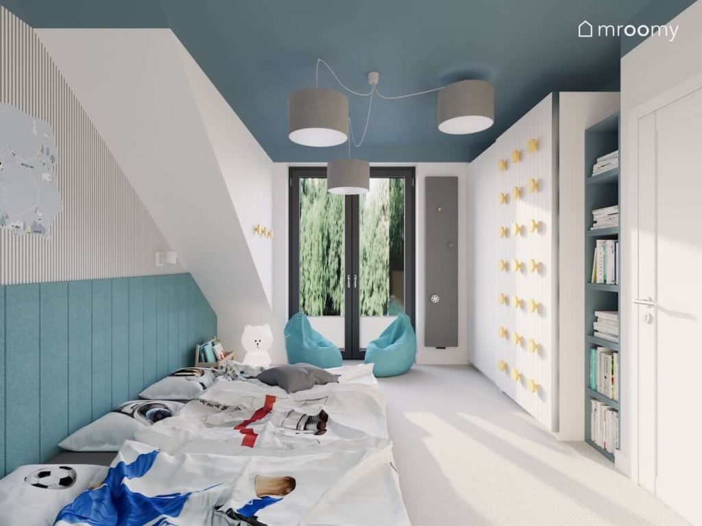 Sypialnia trzech chłopców z materacami i ścianą wyłożoną miękkimi turkusowymi panelami ściennymi kolorowym sufitem szarymi lampami i szafą przesuwną