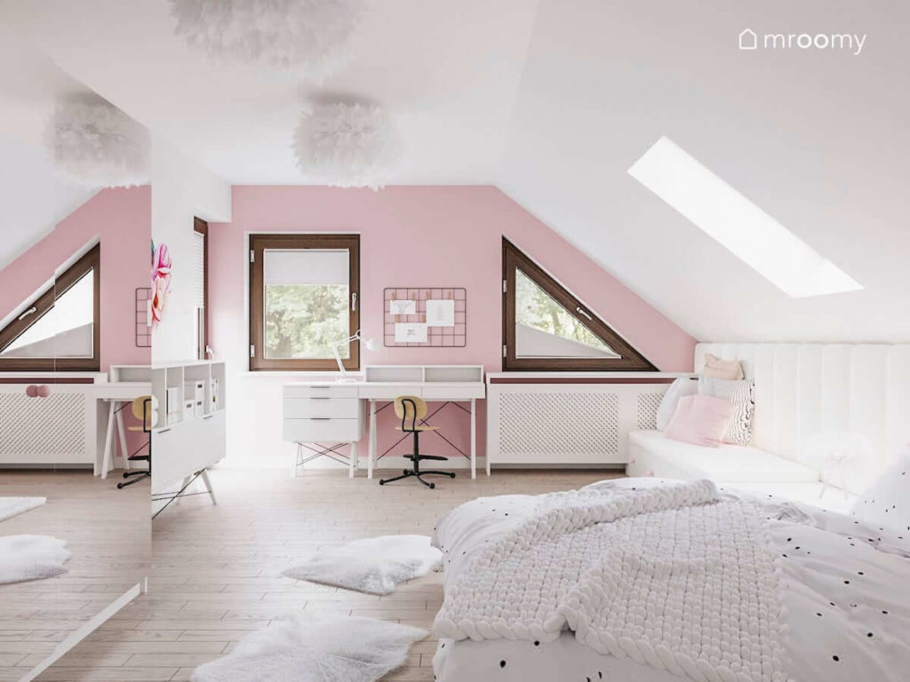 Pokój ze skosami dla dziewczynki w którym jest różowa ściana przy której stoi biurko i duża ściana z lustrem