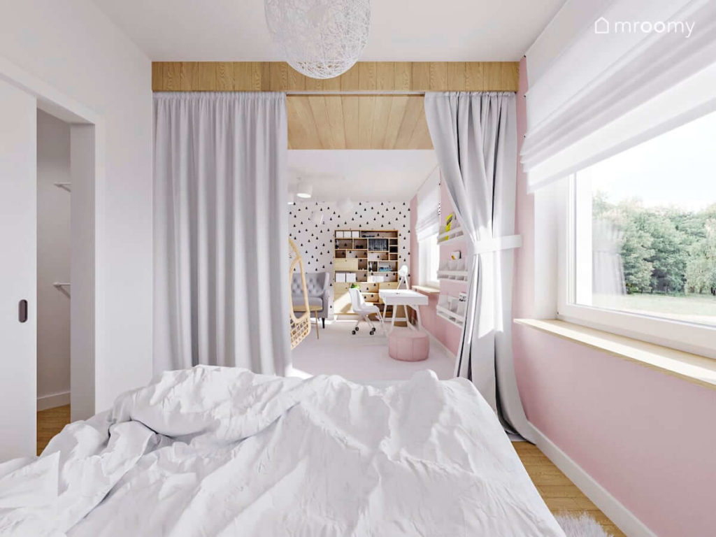 Sypialnia dziewczynki z białymi i różowymi ścianami oddzielona od strefy dziennej szarą kotarą