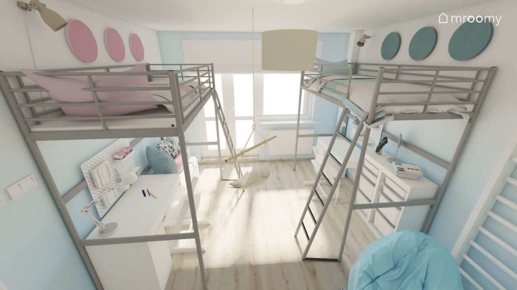Dwie antresole z łóżkami u góry i biurkami na dole w pokoju dwóch dziewczynek ze ścianami z przejściami kolorystycznymi od niebieskiego i różu do bieli
