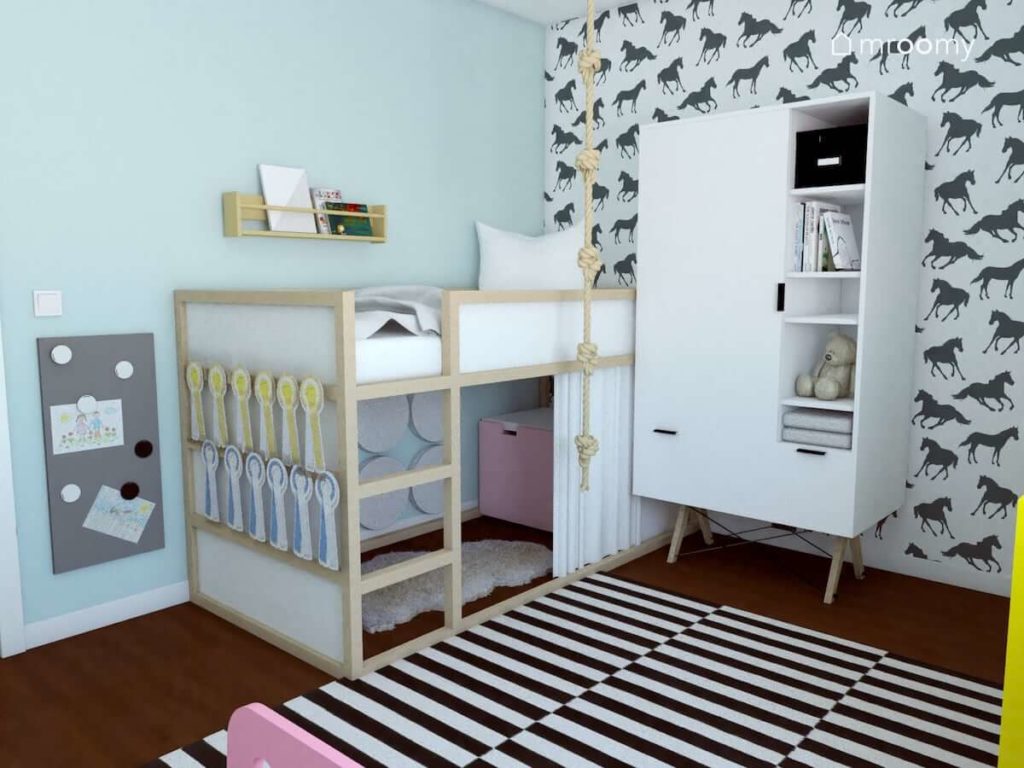 Pokój dla małej dziewczynki z piętrowym łóżkiem szafą na ubrania tapetą w koniki i dywanem w paski