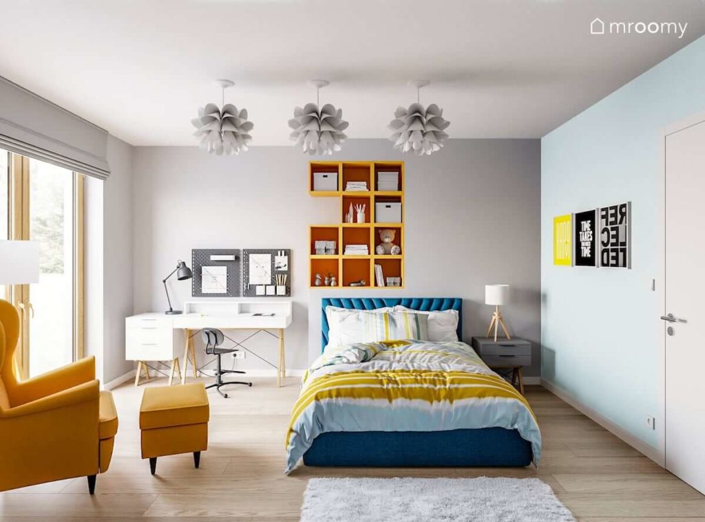 Pokój nastolatki utrzymany w szaro-niebiesko-żółtej tonacji z elementami bieli z dużym łóżkiem i białym biurkiem