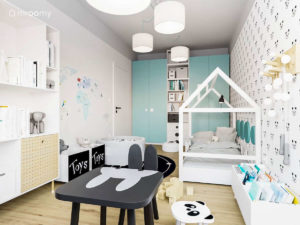 Pokój małego dziecka chłopca lub dziewczynki z łóżkiem domkiem czarnym stolikiem królikiem i dużą szafą z turkusowymi frontami