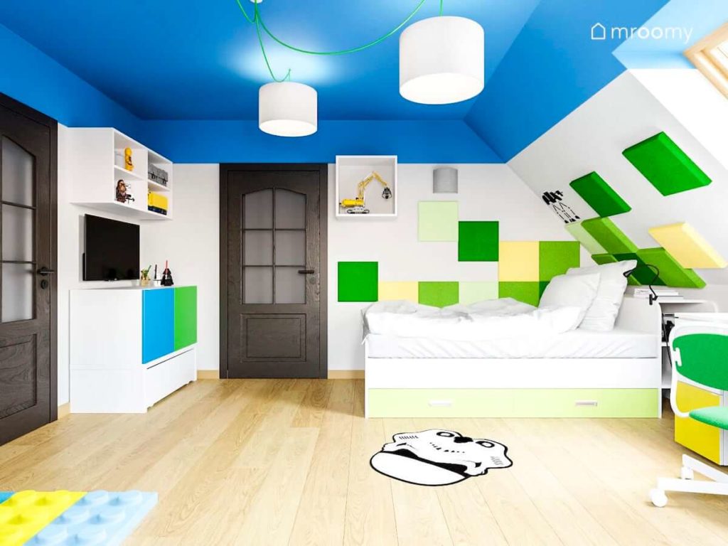 Łóżko w pokoju chłopca z zielonymi panelami ściennymi niebieskim sufitem i naklejką star wars na podłodze