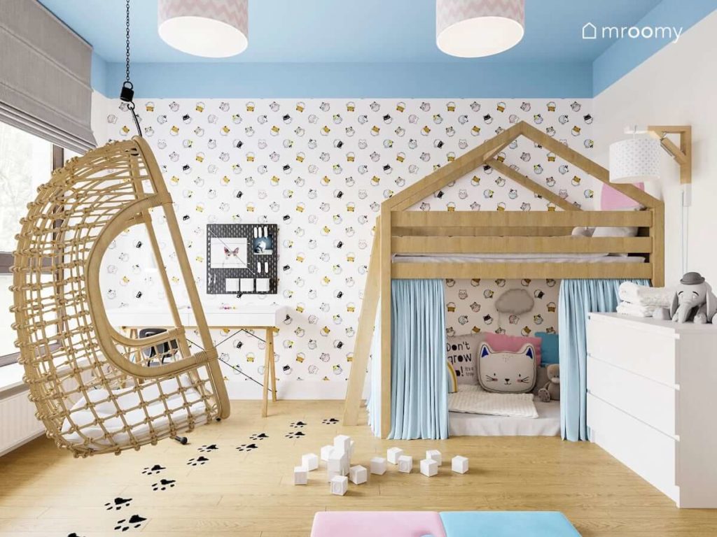 Łóżko domek z zasłonami tapeta w koty huśtawka i biurko w pokoju kilkuletniej dziewczynki