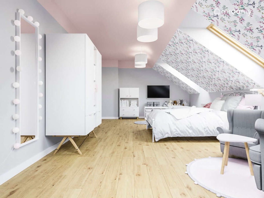 Metalowe duże łóżko białe meble w poddaszowym pokoju dziewczynki z tapetą z motywem ptaków i kwiatów