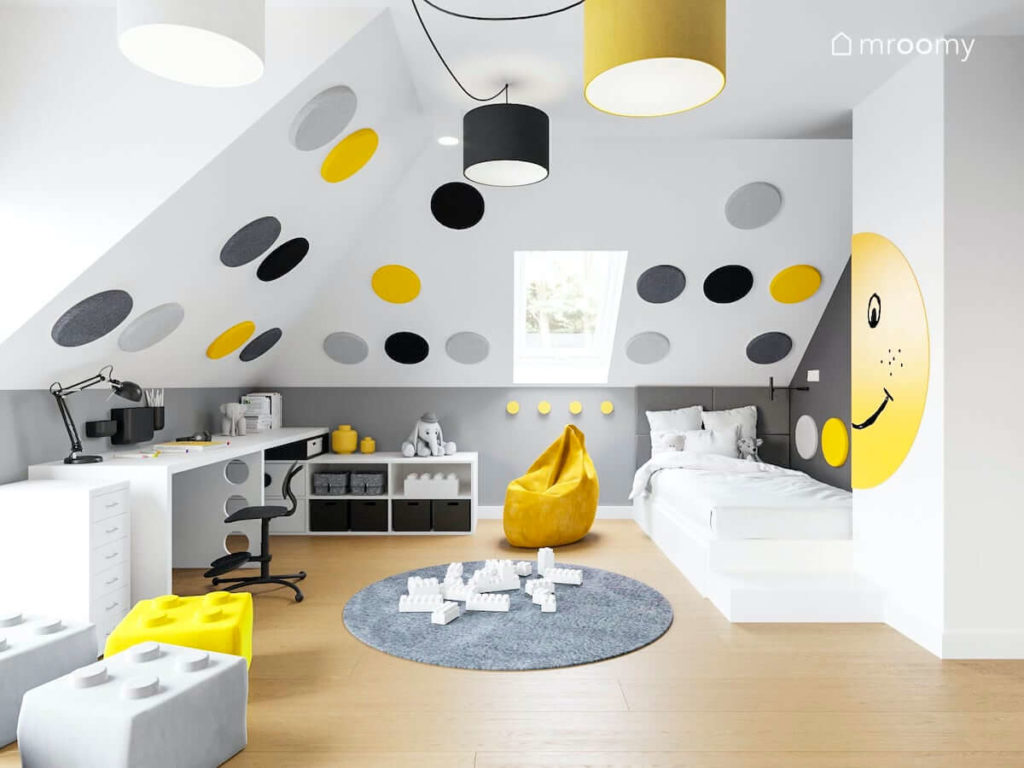 Radosny pokój dziewczynki lub chłopca na poddaszu z dużymi okrągłym panelami ściennymi białym biurkiem i łóżkiem oraz z żółtym workiem sako