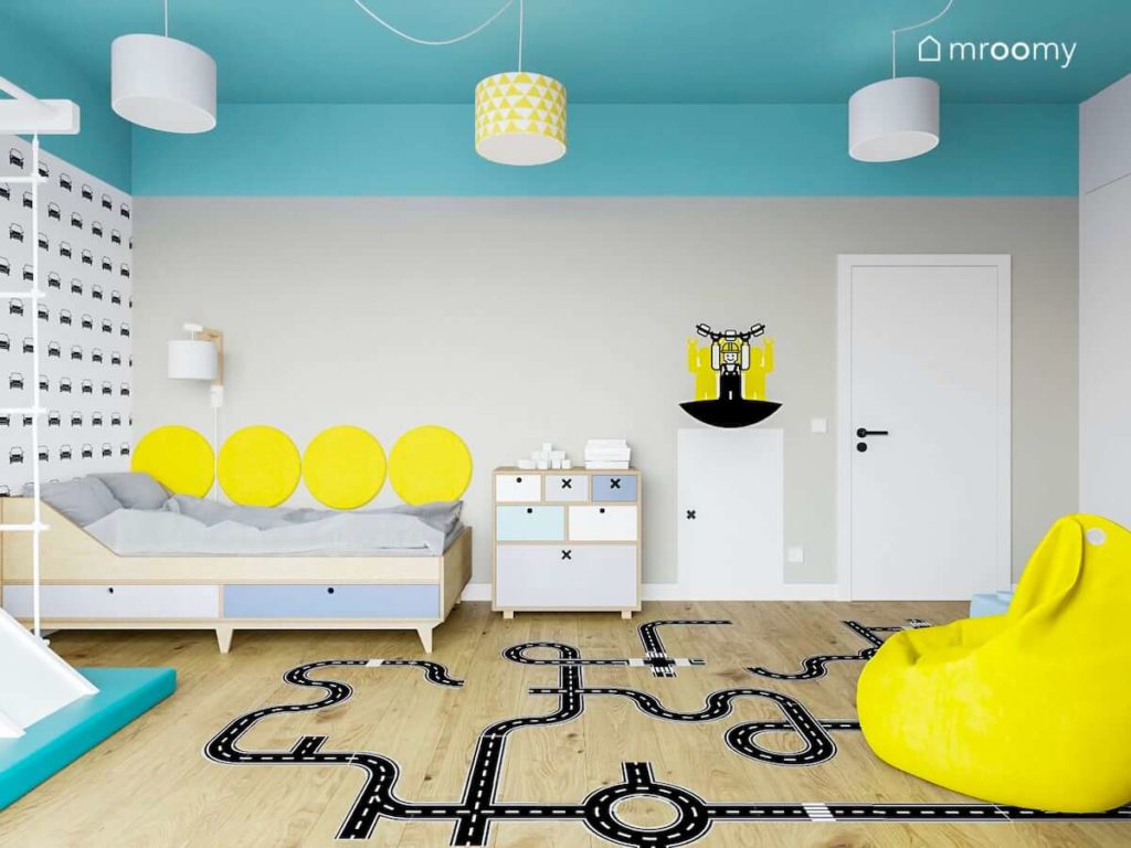 Radosny pokój dziecięcy chłopca z łóżkiem naklejkami podłogowymi żółtymi dodatkami i jasno turkusowym sufitem