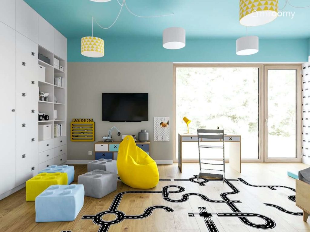 Pufy żółty worek sako niebieski sufit i naklejki podłogowe z ulicą w pokoju chłopca fana lego