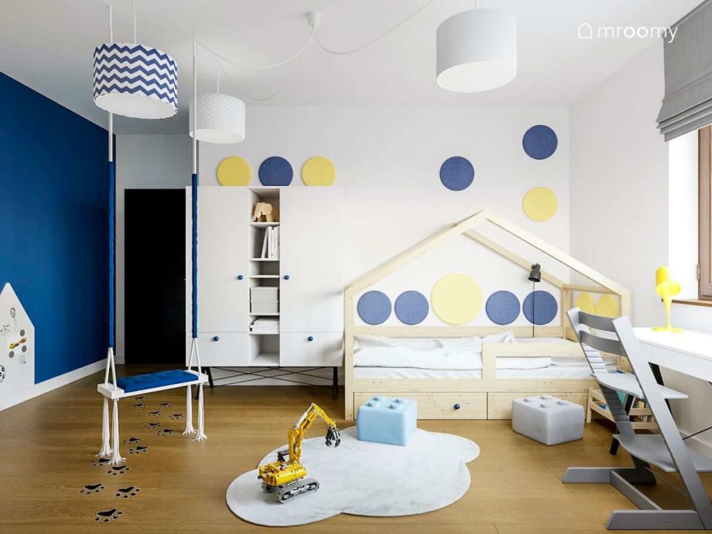 Łóżko domek kolorowe okrągłe panele ścienne dywan chmurka i miękkie pufy lego w pokoju chłopca