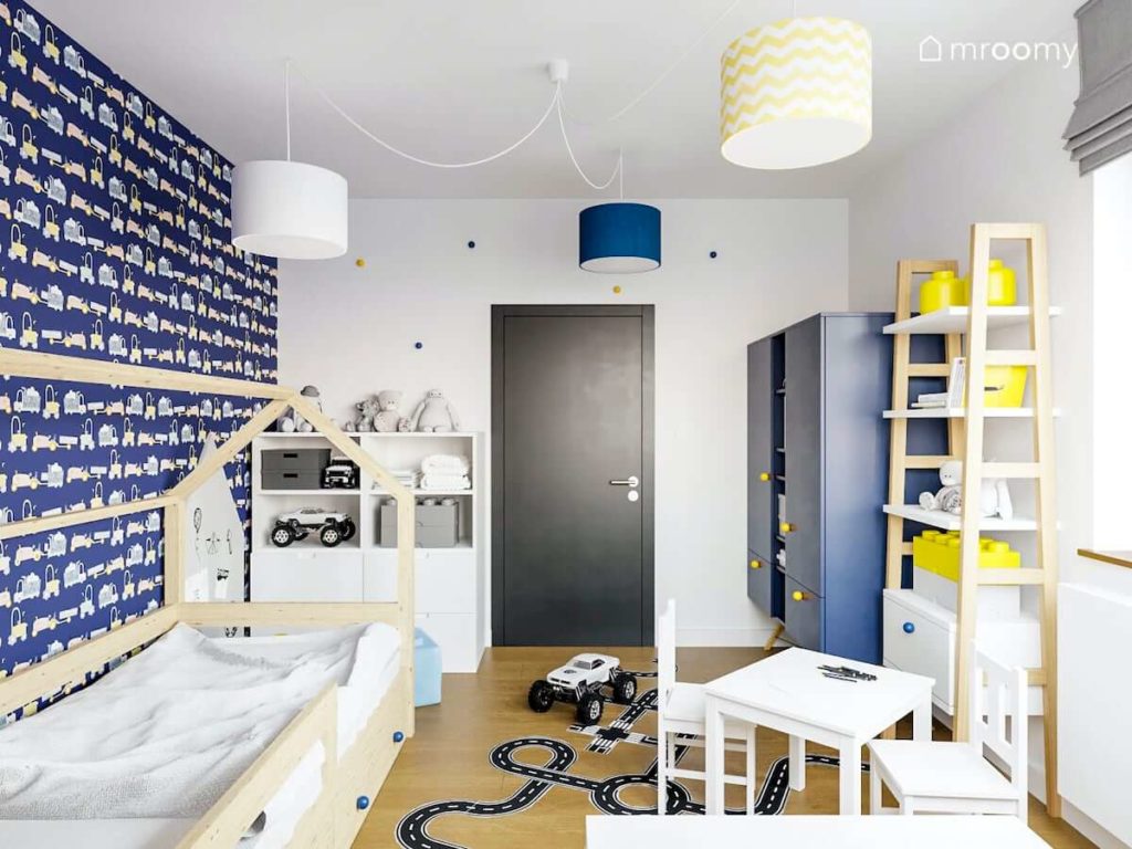 Pokój chłopca przedszkolaka w którym jest łóżko domek niebieskie i białe meble i żółte dodatki