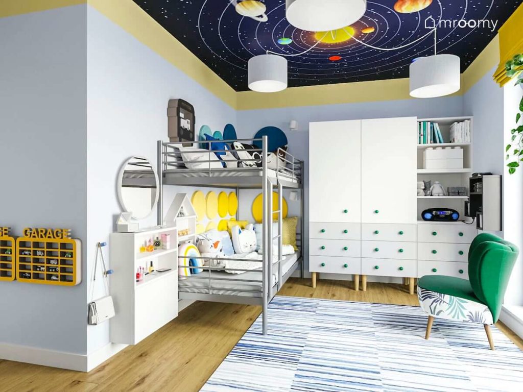 Łóżko piętrowe z miękkimi panelami na ścianie szafa z białymi frontami i motyw kosmosu w pokoju rodzeństwa