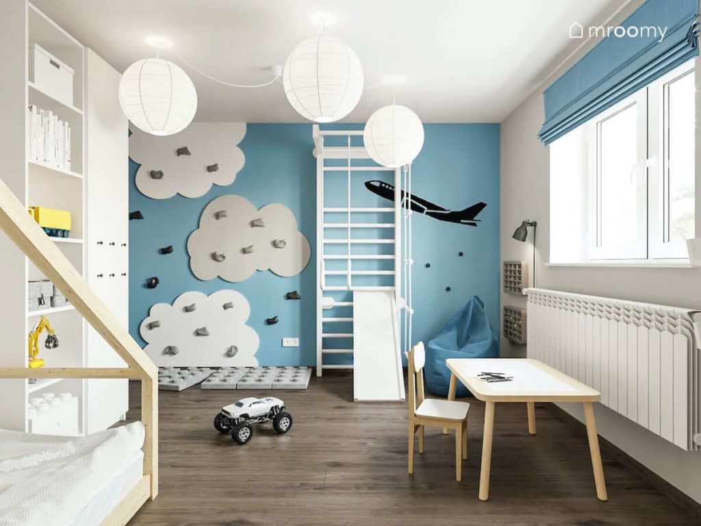 Biała drabinka na niebieskiej ścianie z panelami wspinaczkowymi chmurki w pokoju małego chłopca