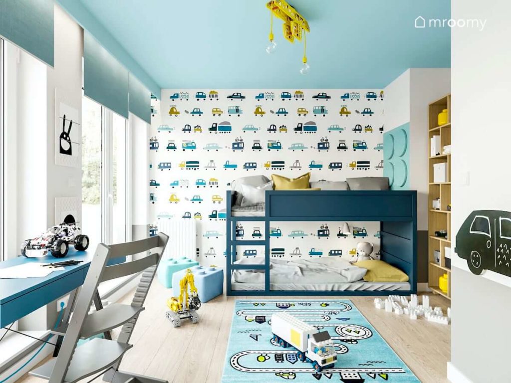 Pomalowane na niebiesko łóżko piętrowe tapeta w samochody i niebieski sufit w pokoju małego chłopca