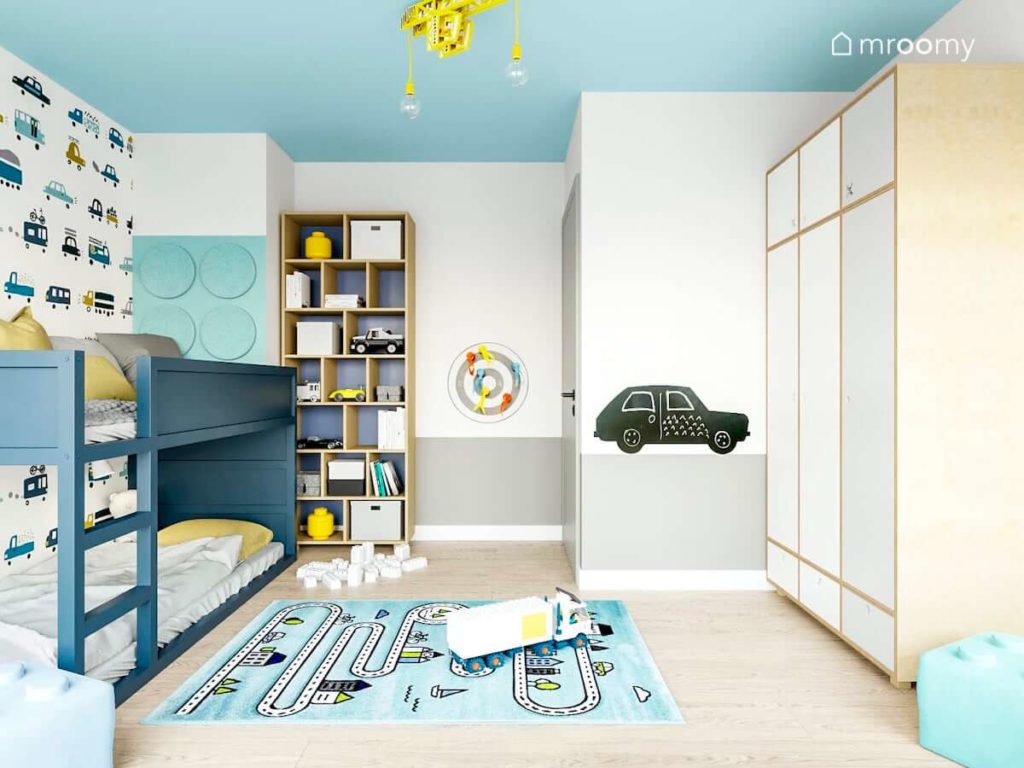 piętrowe łóżko kura przemalowane na kolor niebiesk panele ścienne lego i białe i drewniane meble w pokoju chłopca