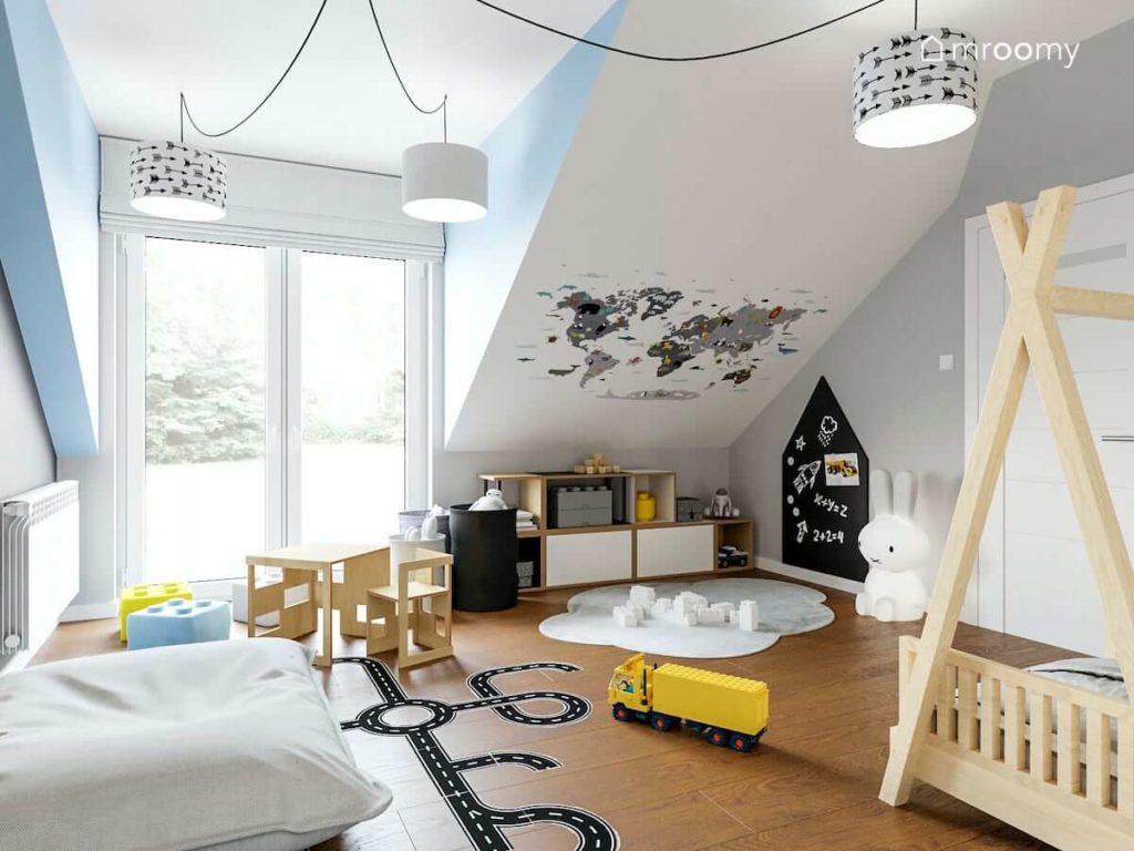 Ścianka wspinaczkowa łóżko tipi tapeta w zwierzątka i naklejki podłogowe w pokoju małego chłopca na poddaszu