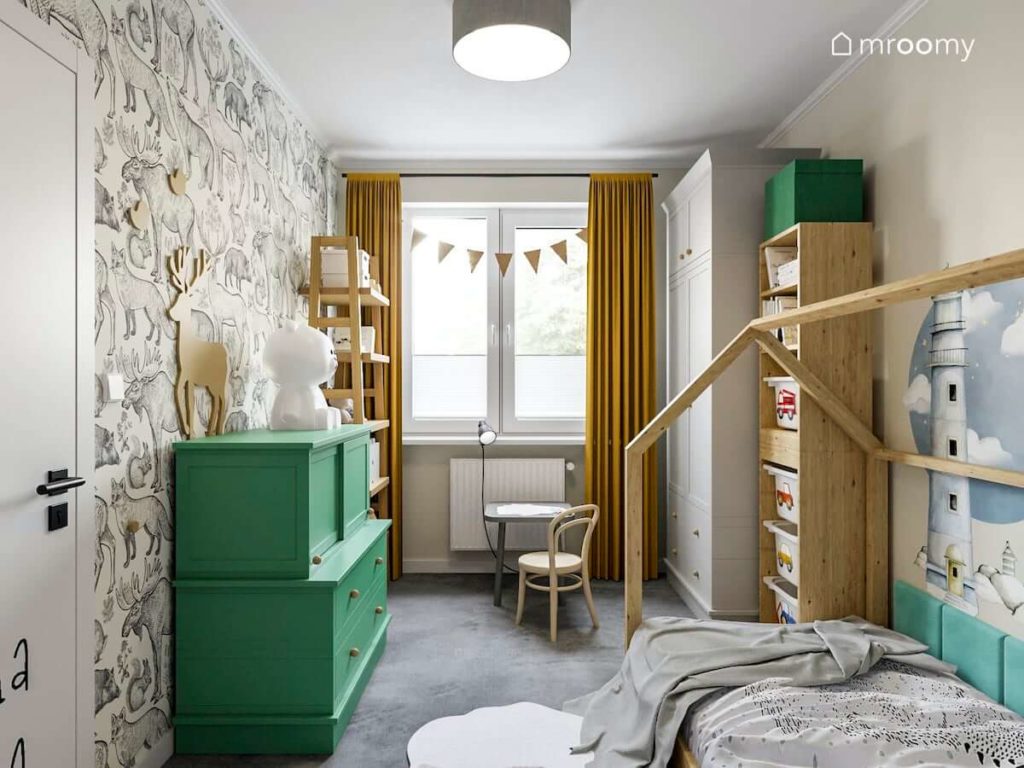 Mały pokój przedszkolaka z tapetą w zwierzątka szarą szafą zieloną komodą i łóżkiem domek