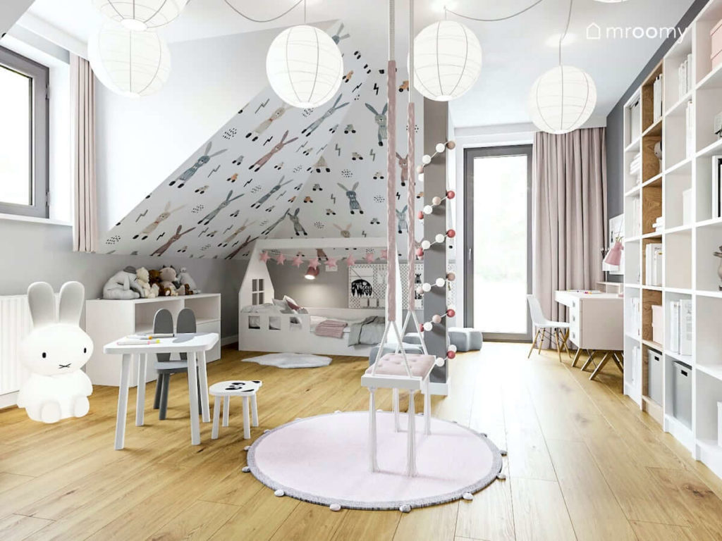 Pokój ze skosami dla małej dziewczynki z huśtawką łóżkiem typu domek w kolorach białym i pudrowego różu
