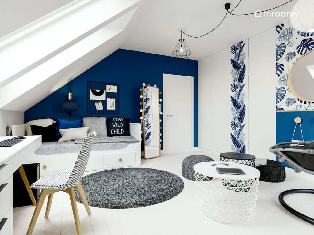 Biało-granatowy pokój nastolatki z białym łóżkiem okrągłymi dywanami i metalowym stolikiem