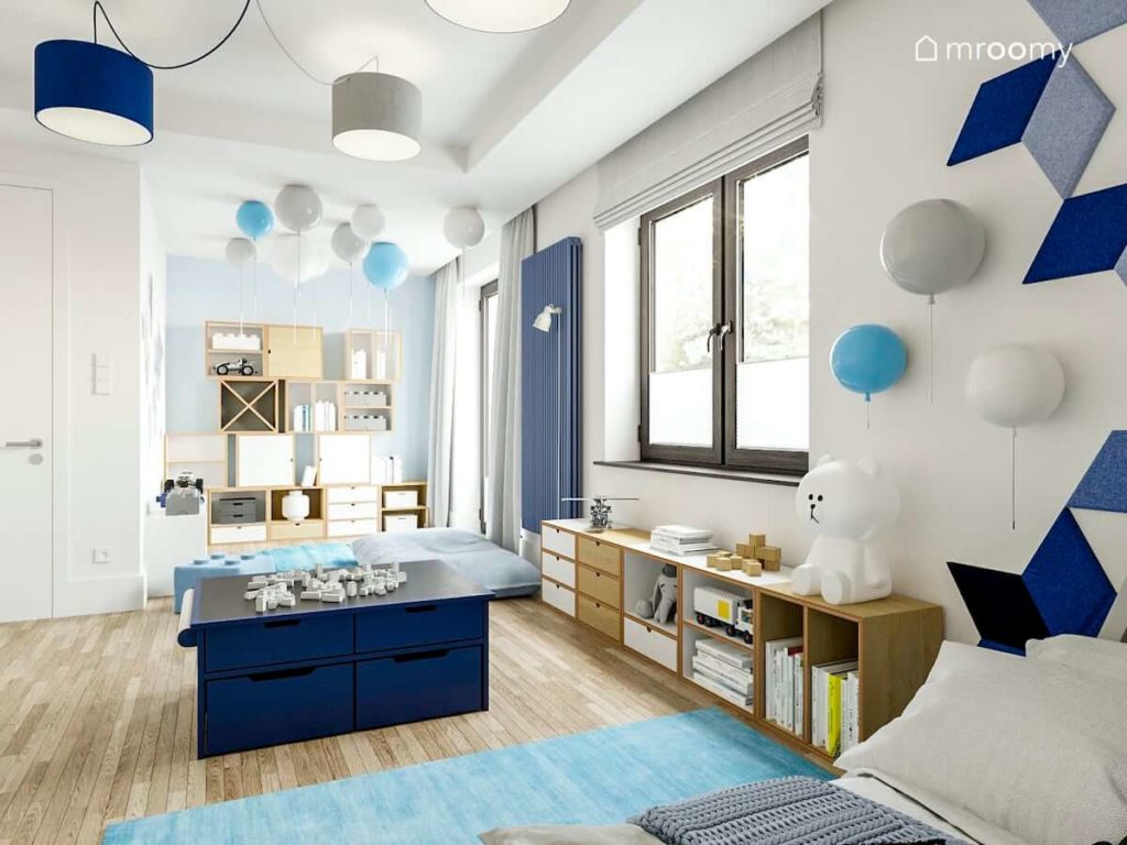 Modułowe meble ze sklejki stolik do zabawy lampy balony błękitny dywan w pokoju dla przedszkolaka