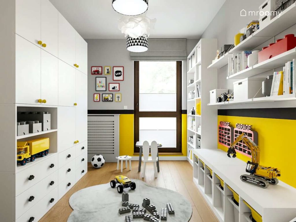 Wąski pokój chłopca przedszkolaka gdzie są białe meble szare ściany i żółte dodatki