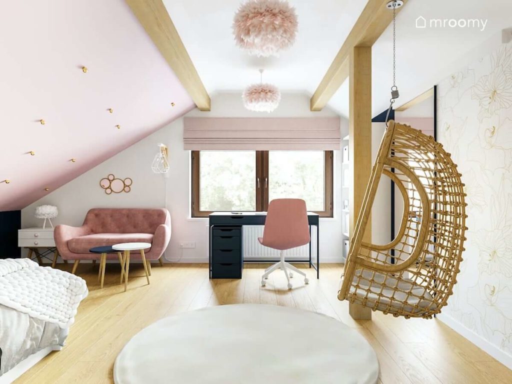 Pokój dla nastolatki na poddaszu z różowymi dodatkami fotelem wiszącym sofą tapicerowaną i miękkim dywanem