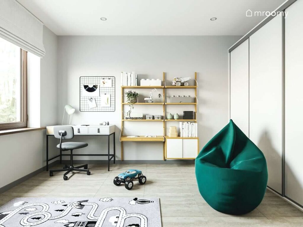 Praktyczny pokój dla chłopca z białym biurkiem drewnianym regałem i wygodną pufą sako