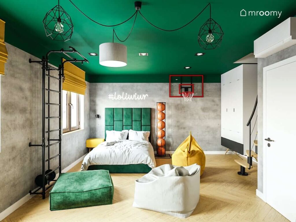 Duże zielone łóżko kolorowe pufy oraz kosz do koszykówki i domowa siłownia w dużym pokoju z zielonym sufitem dla nastolatka