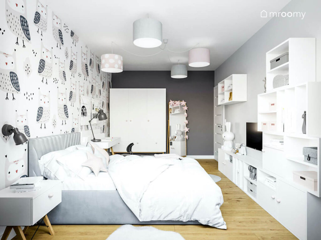 Pokój z przewagą koloru szarego oraz bieli i delikatnego różu dla dziewczynki a w nim białe półki regały szafa i duże łóżko