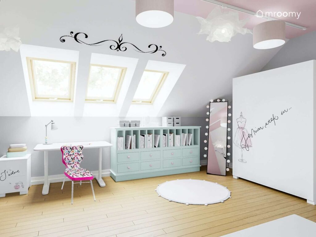 Miętowa komoda biurko lustro stojące i duża szafa w biało różowym poddaszowym pokoju dla dziewczynki