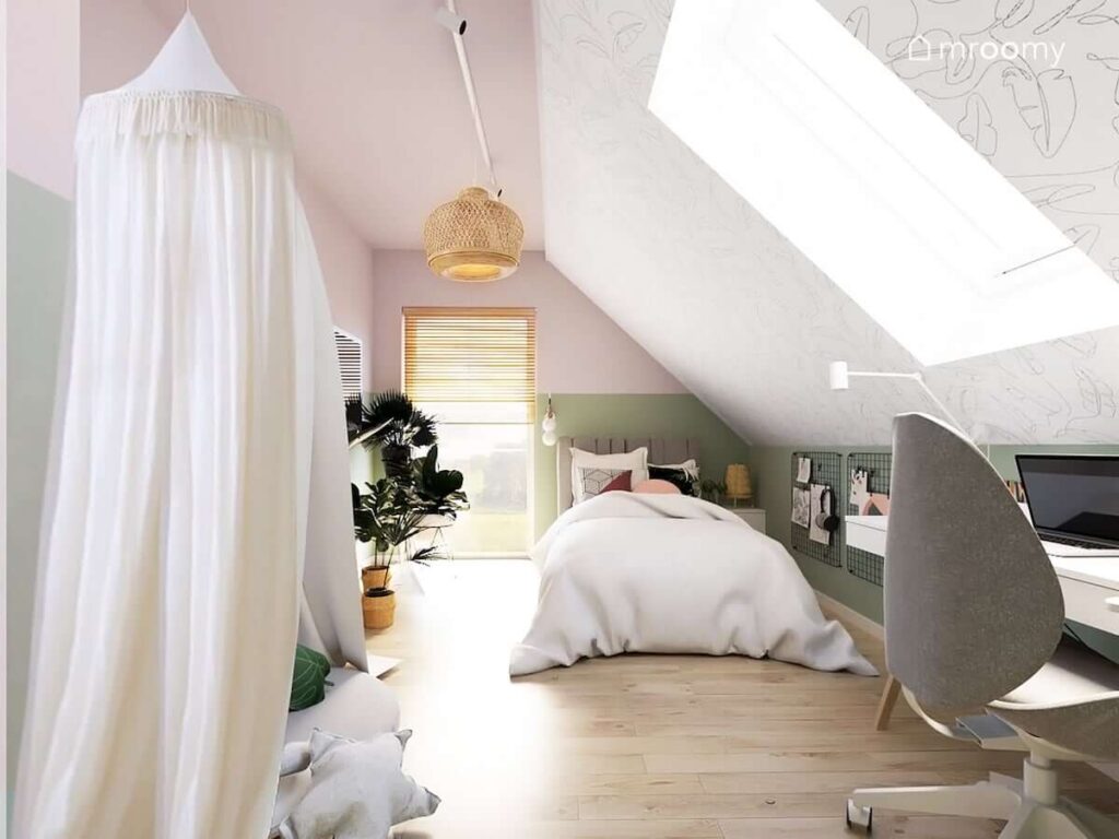 Różowo zielony pokój dla dziewczynki z tapetą w liście na skośnej ścianie oraz tapicerowanym łóżkiem i miękkim kącikiem wypoczynkowym z baldachimem