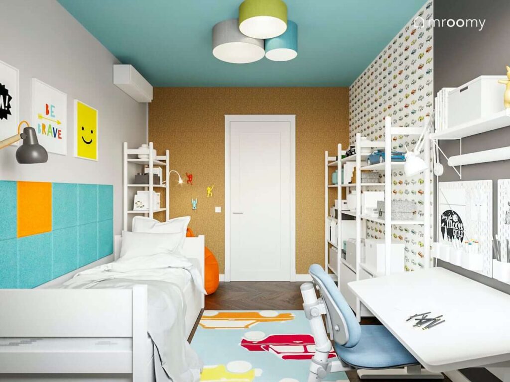 rozsuwanym łóżkiem z szufladami pomarańczowym workiem sako i miękkimi panelami ściennymi przy łóżku