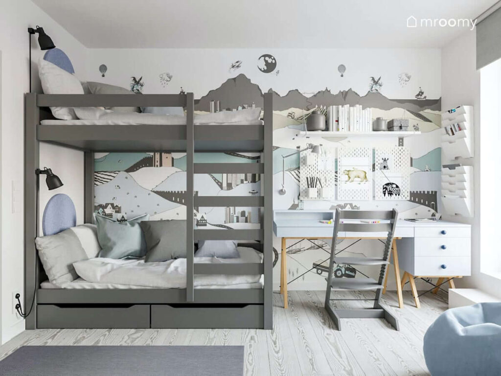 Pokój dla braci z szarym łóżkiem piętrowym błękitnym nowoczesnym skandynawskim biurkiem krzesłem z podnóżkiem ozdobiony tapetą przedstawiającą krajobraz miasta utrzymany w kolorystyce szaro-błękitnej- białej
