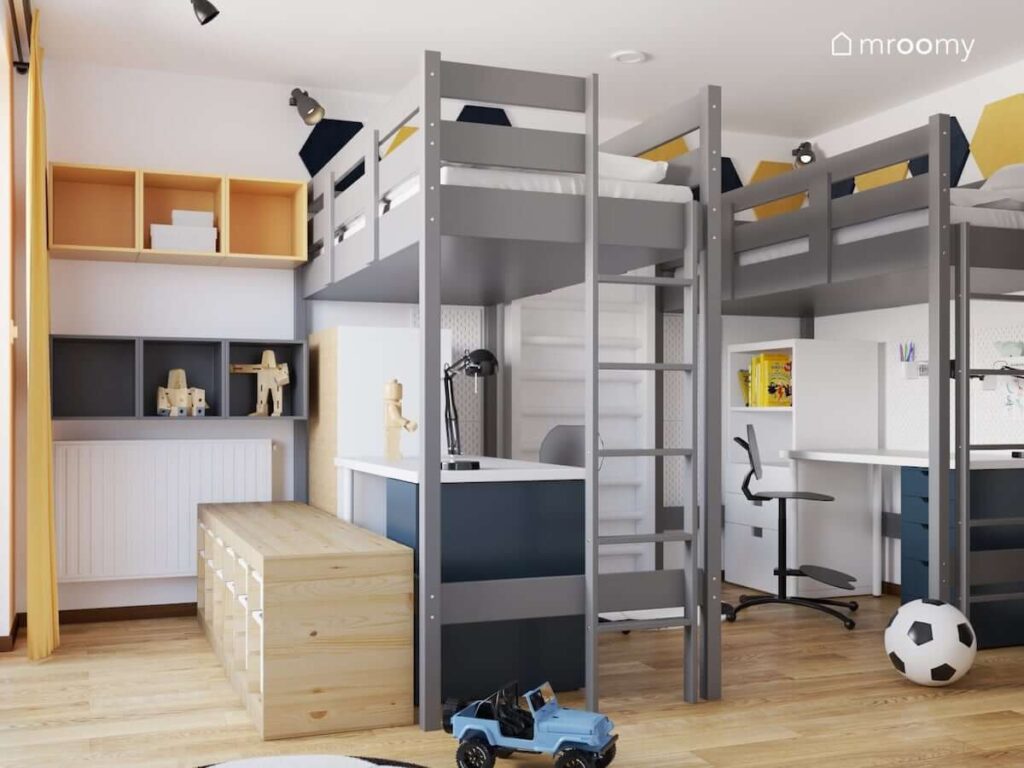 Pokój dla dwóch braci z szarymi łóżkami na wysokich antresolach biurkami oraz regałami a także szafkami ściennymi w różnych kolorach