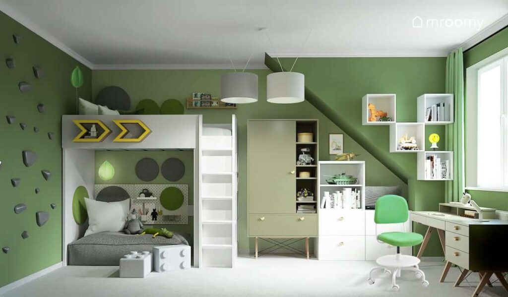 Zielony pokój dla kilkuletniego chłopca z łóżkiem na antresoli białymi i zielonymi meblami ścianką wspinaczkową oraz przytulnym kącikiem pod antresolą