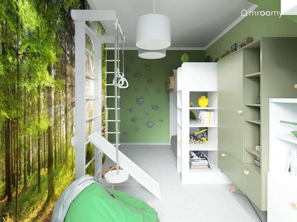 Zielony pokój dla chłopca z drabinką gimnastyczną oraz zieloną pufą a także łóżkiem na antresoli i zieloną szafą