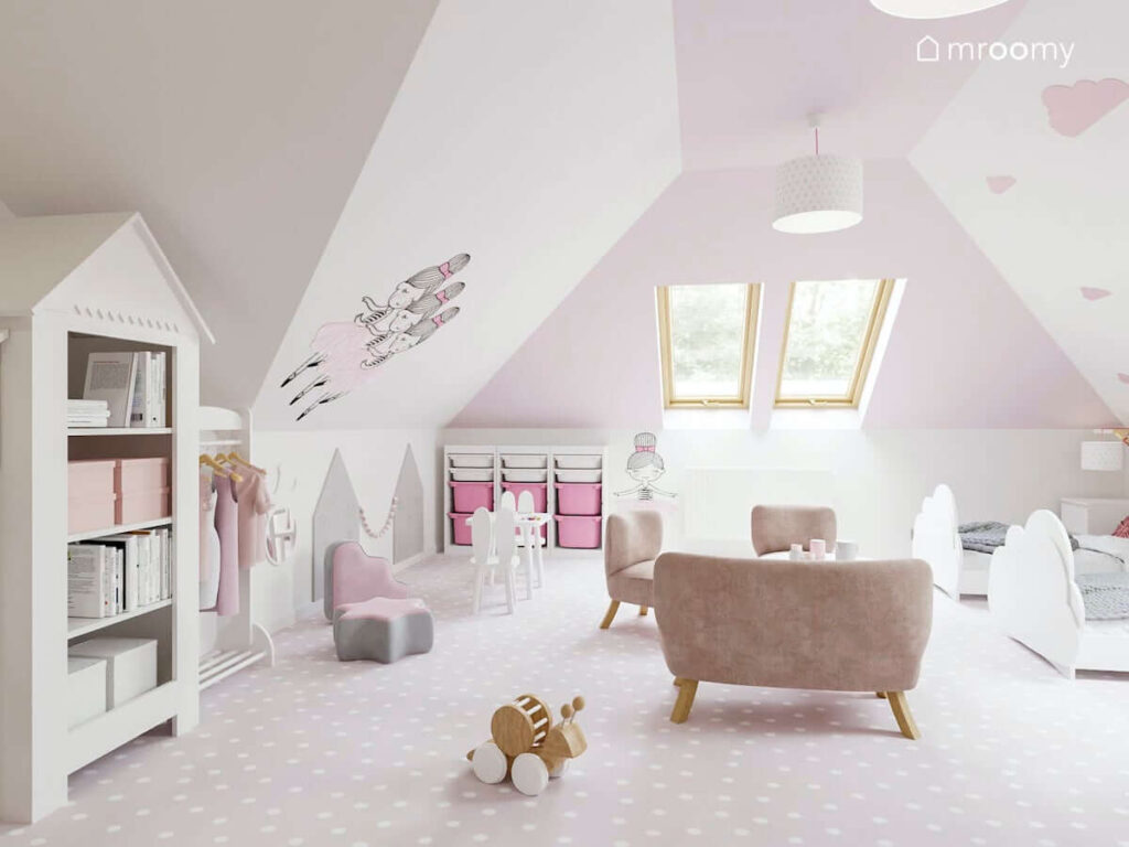 Pokój dla sióstr biało-różowy na poddaszu z oknami połaciowymi łóżkami w kształcie chmurek pufą w kształcie gwiazdki i chmurki pojemnym regałem na zabawki z kolorowymi pojemnikami stolikiem z krzesełkami w kształcie królika