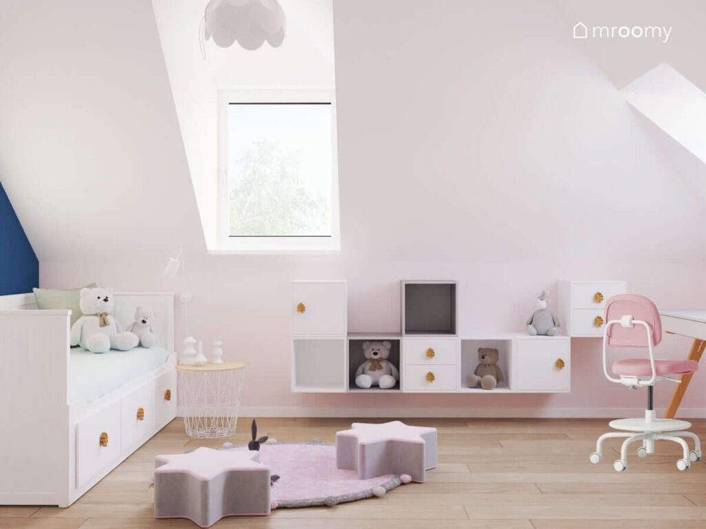 Jasny pokój dla dziewczynki z białymi i szarymi szafkami ściennymi oraz łóżkiem z szufladami a także drewnianymi gałkami do mebli w kształcie liści