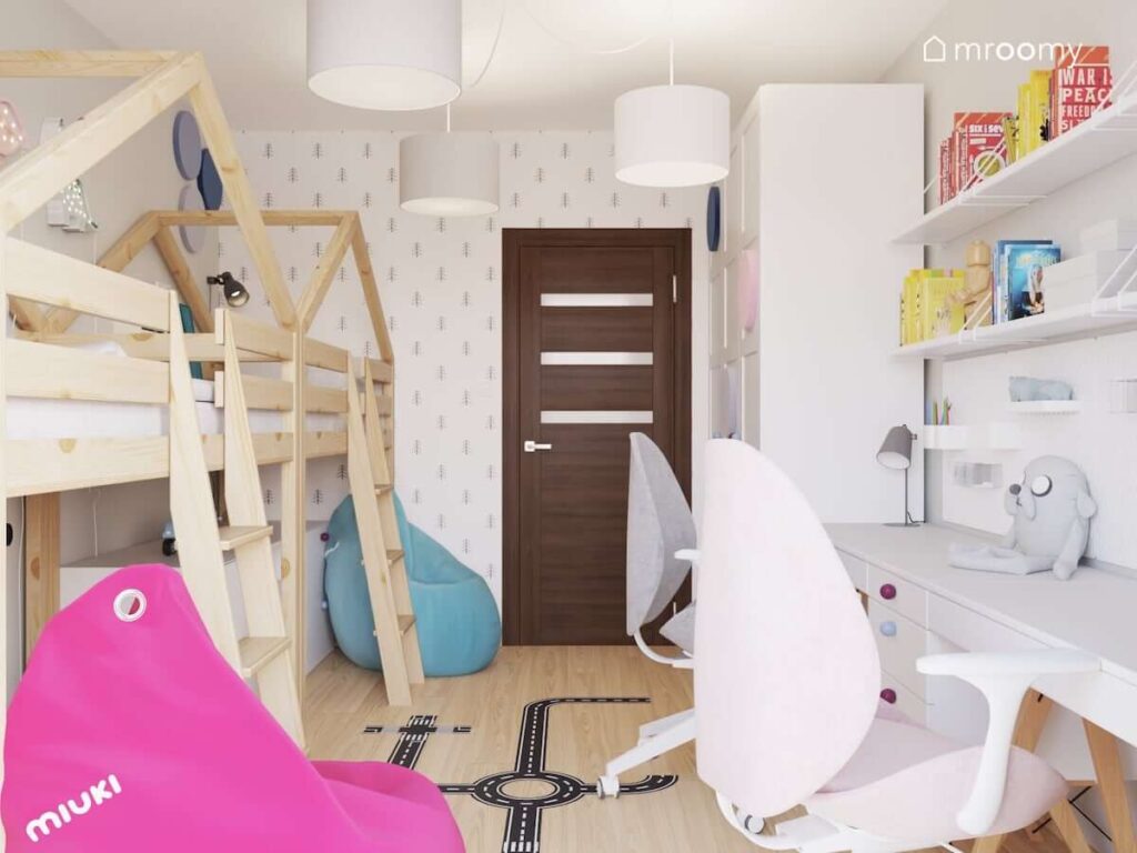 Pokój dla chłopca i dziewczynki z drewnianymi antresolami w kształcie domków kolorowymi pufami oraz biurkami i licznymi półkami ściennymi i tapetą w choinki na jednej ze ścian