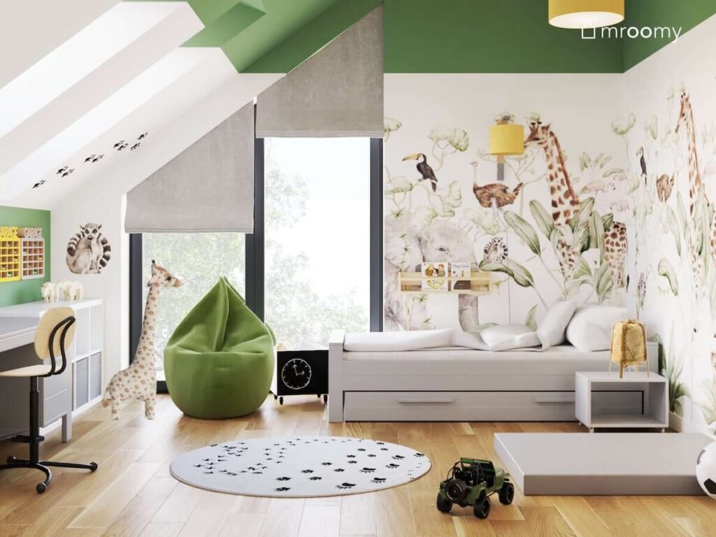 Biało zielony pokój dla chłopca z tapetą z dzikimi zwierzętami białymi meblami oraz zieloną pufą sako i dywanem w łapki