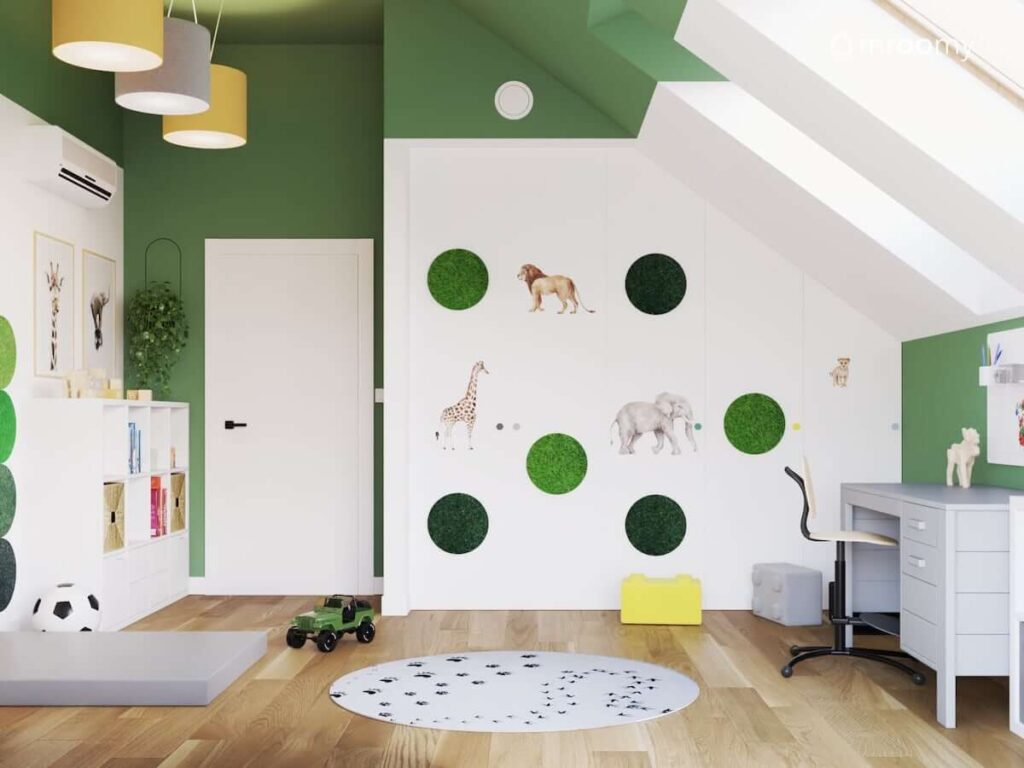 Duża biała szafa wnękowa ozdobiona zielonymi panelami ściennymi i naklejkami z dzikimi zwierzętami w biało zielonym pokoju dla chłopca