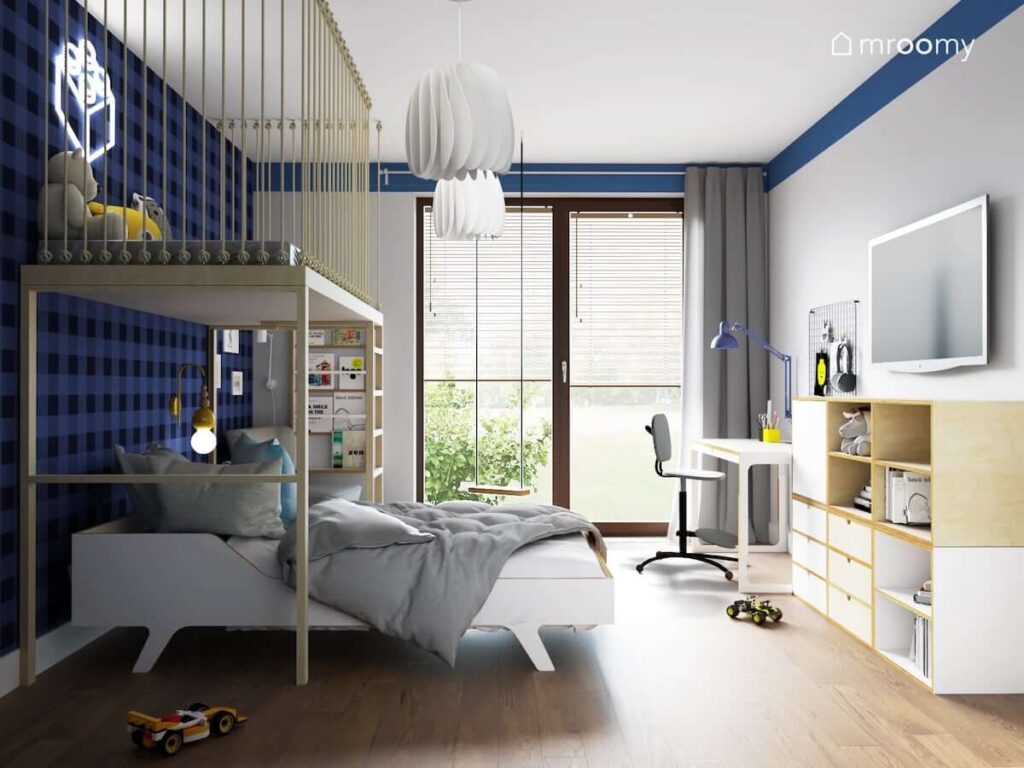 Biało niebieski pokój dla chłopca z regałem modułowym ze sklejki białym biurkiem oraz łóżkiem nad którym znajduje się antresola