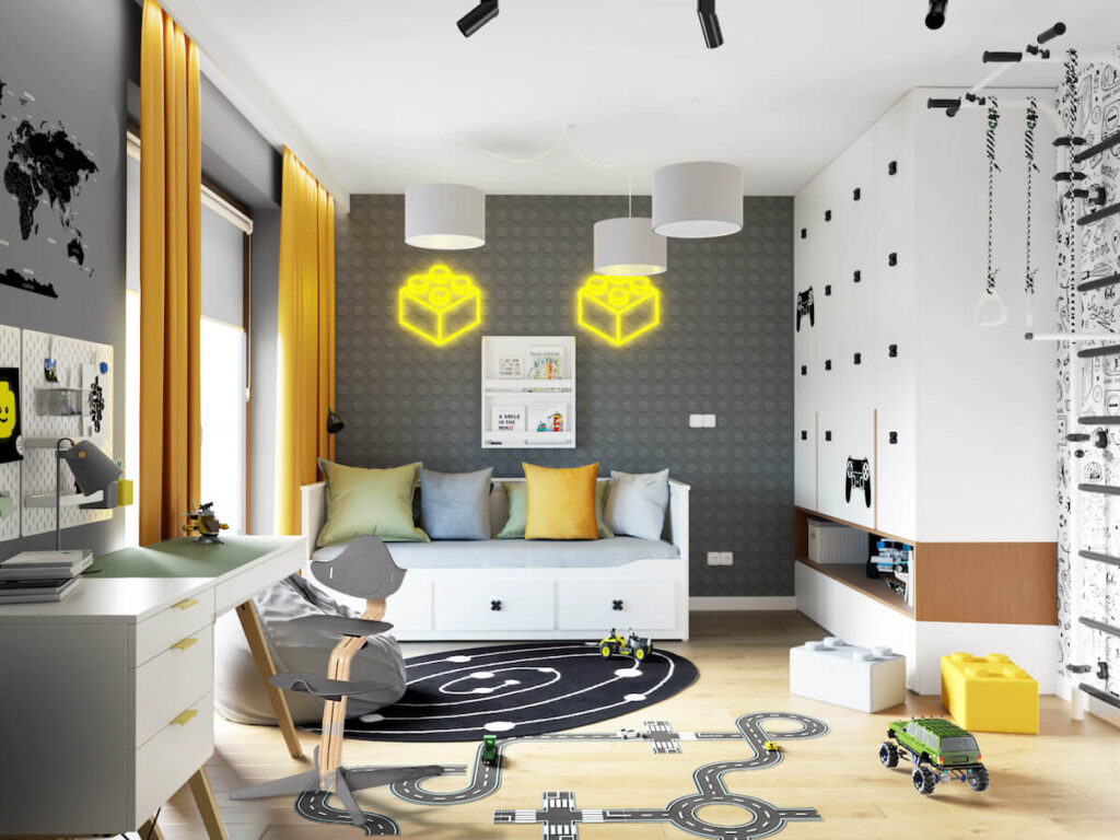 Pokój dla chłopca z dużą białą szafą łóżkiem z szufladami i biurkiem na drewnianych nogach a także z ledonami w kształcie klocków i ścianą której wzór przypomina klocek Lego na podłodze naklejka w kształcie ulicy